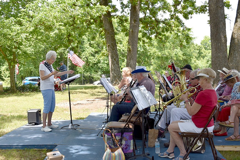 Rachel Dickerson/The Weekly Vista Lois Carlson, left, directs the Ecumenical Church Orchestra (ECHO) in a patriotic song during the Memorial Day observance at Bella Vista Memorial Garden Cemetery on Monday.