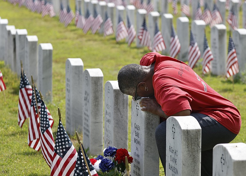 Lynette Brown kisses the headstone of her brother, Galen Brown, while visiting his grave on Monday, May 29, 2023, after the Memorial Day wreath laying ceremony at the Arkansas State Veterans Cemetery in North Little Rock. 
More photos at www.arkansasonline.com/530memday/
(Arkansas Democrat-Gazette/Thomas Metthe)