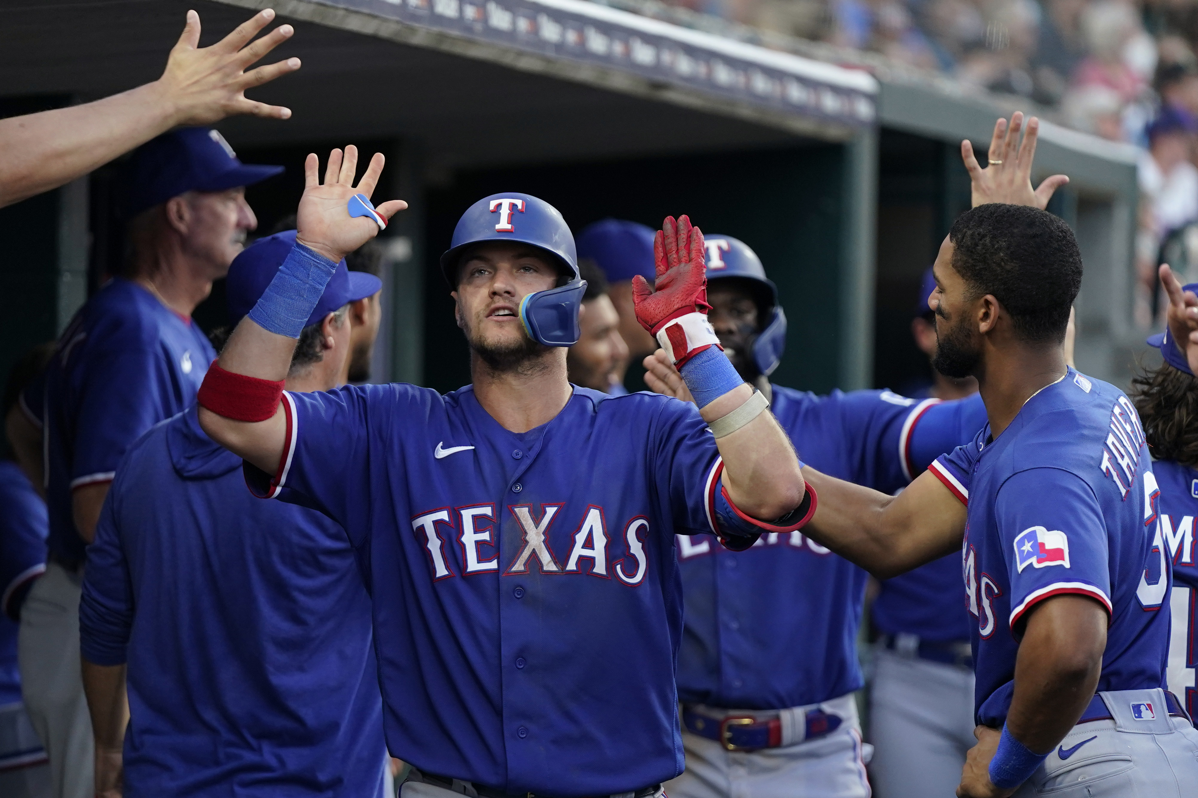 Texas Rangers' Elvis Andrus smiles in the dugout after he scored