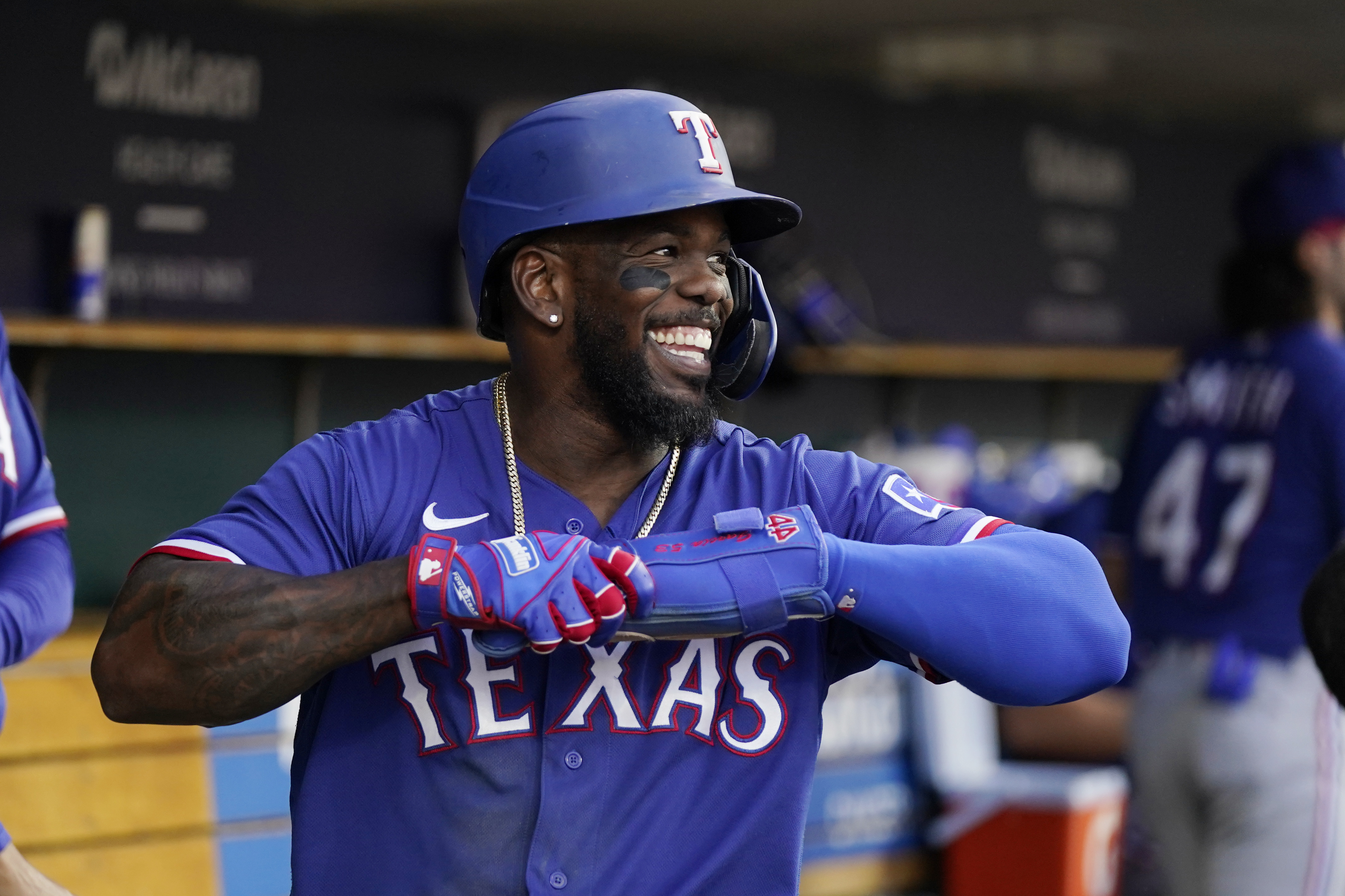 Texas Rangers' Elvis Andrus smiles in the dugout after he scored