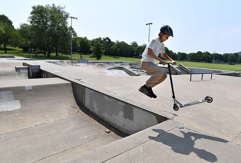 Travis Gaude, 14, performs a trick Friday, May 26, 2023, while riding a scooter at the now nearly 20-year-old Grinders Skate Park in Walker Park in Fayetteville. The city is seeking input for improvements and additions to the park as it creates a master plan for planned renovations. Visit nwaonline.com/photo for today's photo gallery. 
(NWA Democrat-Gazette/Andy Shupe)