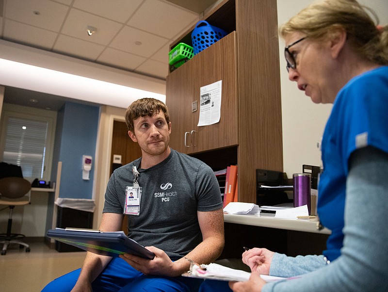 David Bratten, left, listens as Deb Salings confirms notes she took from Bratten's report Thursday at SSM Health St. Mary's Hospital, in Jefferson City. Salings will retire in two weeks after 43 years of work. (Kate Cassady/News Tribune)