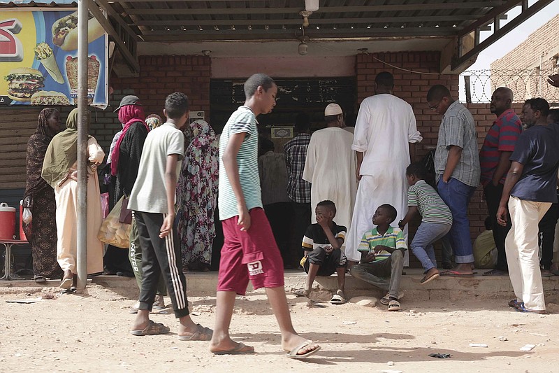 People line up in front of a bakery during a cease-fire on Saturday in Khartoum. Saudi Arabia and the United States say the warring parties in Sudan are adhering better to a week-long cease-fire after days of fighting. (AP/Marwan Ali)