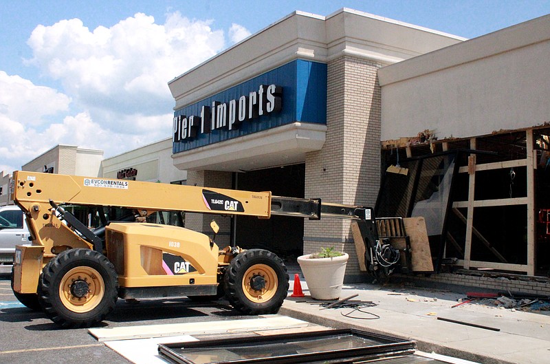 A worker using a telehandler works to remove a window of the former Pier 1 Imports in Cornerstone Market Place. The former home decor retail location, as well as the Chick-fil-A restaurant next door, are being demolished to pave the way for a new larger Chick-fil-A. - Photo by Lance Porter of The Sentinel-Record