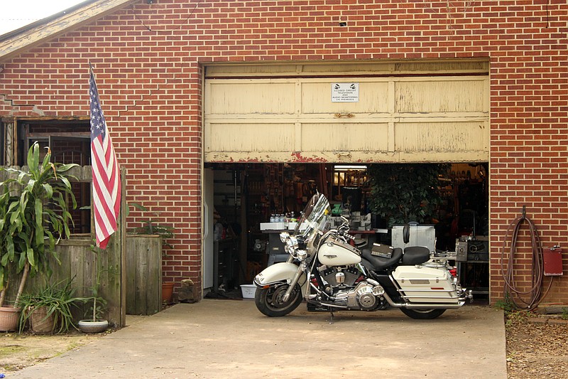 A motorcycle sits in front of the entrance to the garage of a building in the 400 block of Ferguson street Thursday afternoon, June 1, 2023, in Texarkana, Ark. Officers are conducting an investigation into firearms reportedly discovered on the property. (Staff photo by Stevon Gamble)