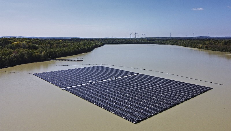 FILE - Solar panels on Germany's biggest floating photovoltaic plant produce energy under a blue sky on a lake in Haltern, Germany, Tuesday, May 3, 2022. The world is set to add a record amount of renewable electricity capacity this year as governments and consumers seek to offset high energy prices and take advantage of a boom in solar power. (AP Photo/Martin Meissner, File)