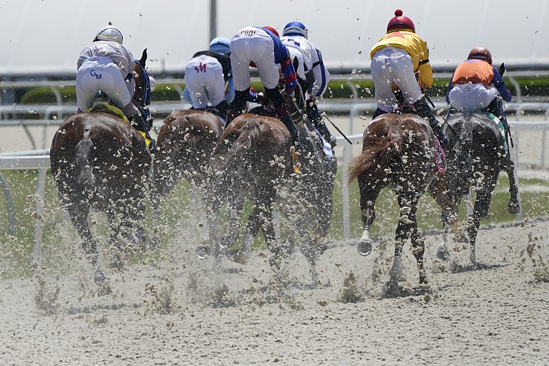 FILE - Horses kick up the new synthetic track surface as they race at Gulfstream Park, Thursday, Sept. 30, 2021, in Hallandale Beach, Fla. From owners to trainers to jockeys to bettors, the debate is vigorous on whether synthetic surfaces are a potential answer to creating safer training and racing conditions. (AP Photo/Wilfredo Lee, File)