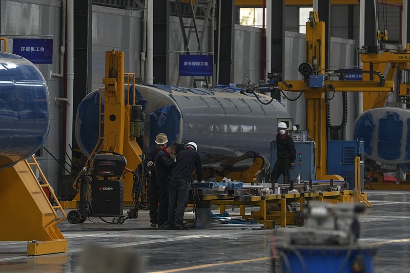 Workers assemble the Dongfeng truck at a manufacturing factory in Shiyan city in central China's Hubei Province on May 12, 2023. China's factory activity decelerated in May, a survey showed Wednesday, May 31 adding to signs its economic rebound after the end of anti-virus controls is slowing. (AP Photo/Andy Wong)