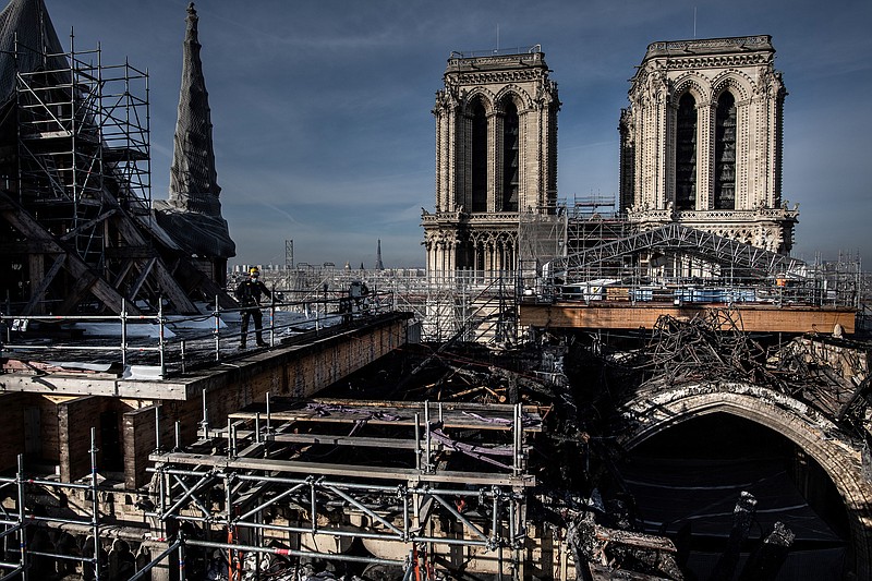 Workers on the roof of Notre-Dame work to remove the burnt scaffolding which hampered the safety of the cathedral damaged by the April 15, 2019 fire on Nov. 24, 2020, in Paris. (Martin Bureau/AFP/Getty Images)