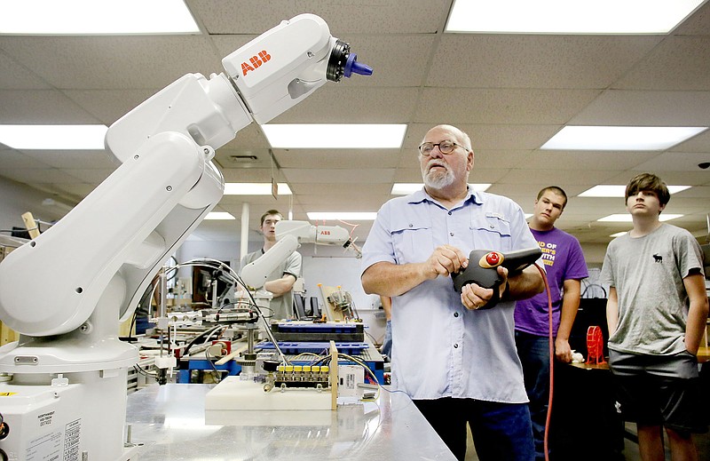 Instructor Billy Graham (center) controls an industrial robot ABB 120 in the Electronics Lab at Northwest Technical Institute in Springdale. (NWA Democrat-Gazette/FILE PHOTO)