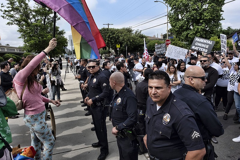 Protesters shout slogans and carry signs as Los Angeles police officers separate them from counter-protesters at the Saticoy Elementary School in the North Hollywood section of Los Angeles on Friday, June 2, 2023. Police officers separated groups of protesters and counter-protesters Friday outside a Los Angeles elementary school that has become a flashpoint for Pride Month events and activities across California.People protesting a planned Pride Month assembly outside the Los Angeles Unified School District's Saticoy Elementary School wore T-shirts imprinted with "Leave our kids alone" and carried signs with slogans such as "Parental Choice Matters" and "No Pride in Grooming." (AP Photo/Richard Vogel)