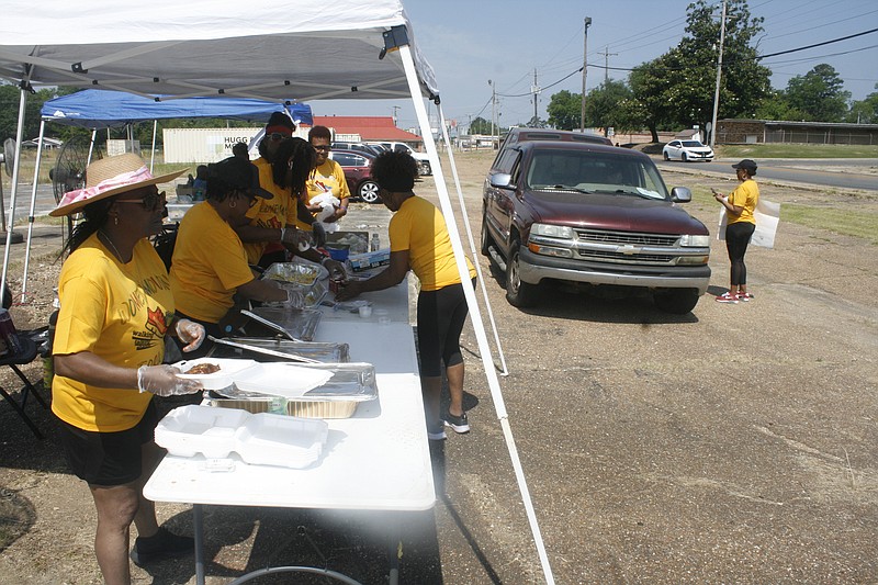 Members of Women Moving Forward serve lunch plates at a fundraiser held on Saturday. (Matt Hutcheson/News-Times)