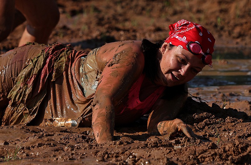 Kirsten Cox tries to extricate herself from the mud pit during the annual Mud Run near War Memorial Stadium on Saturday, June 3, 2023. See more photos at arkansasonline.com/604mudrun/ (Arkansas Democrat-Gazette/Colin Murphey)