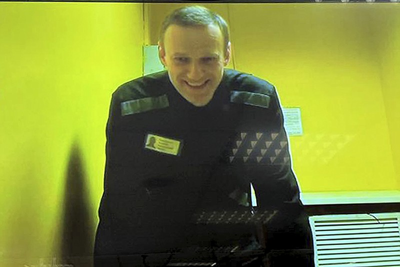 In this handout photo released by Moscow City Court Press Service, Russian opposition leader Alexei Navalny is seen on a TV screen, as he appears in a video link provided by the Russian Federal Penitentiary Service in a courtroom at Moscow City Court in Moscow, Russia, Wednesday, May 31, 2023. Imprisoned Russian opposition leader Alexei Navalny said in April that he was facing new extremism and terrorism charges that could keep him behind bars for life. (Moscow City Court Press Service via AP)