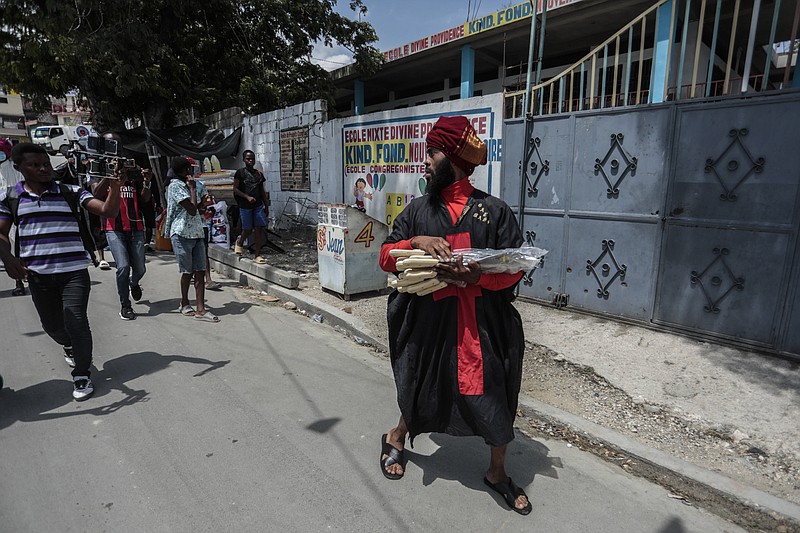 Nertil Marcelin, leader of a community group, goes door-to-door to distribute machetes to residents in an initiative to resist gangs seeking to take control of their neighborhood, in the Delmas district of Port-au-Prince, Haiti, Saturday, May 13, 2023. (AP Photo/Odelyn Joseph)