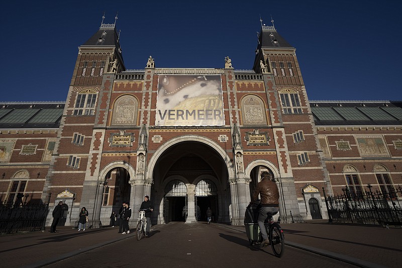 FILE - Cyclists pass under the Vermeer exhibit sign at Amsterdam's Rijksmuseum, Monday, Feb. 6, 2023. The blockbuster exhibition of paintings by Dutch Master Johannes Vermeer closed its doors for the final time Sunday, June 4, with the art and history national museum of the Netherlands hailing the show as its most successful ever. (AP Photo/Peter Dejong, file)