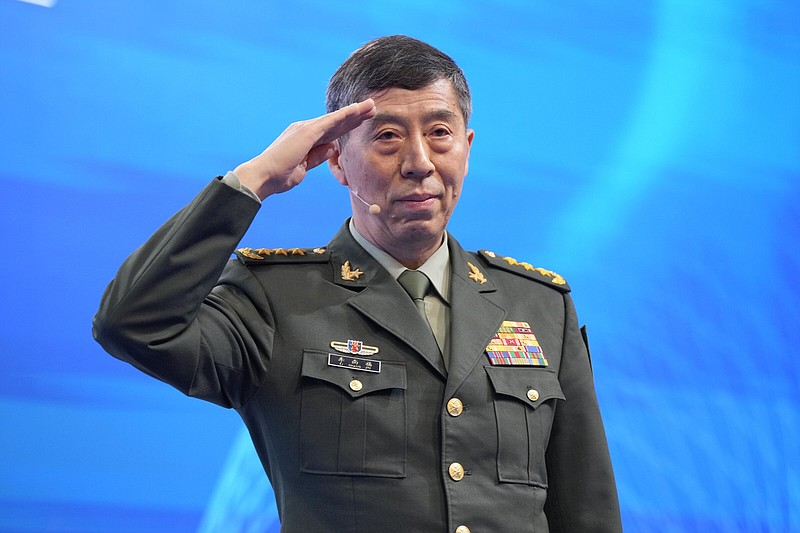 Chinese Defense Minister Li Shangfu salutes before delivering his speech on the last day of the 20th International Institute for Strategic Studies (IISS) Shangri-La Dialogue, Asia's annual defense and security forum, in Singapore, Sunday, June 4, 2023. (AP Photo/Vincent Thian)