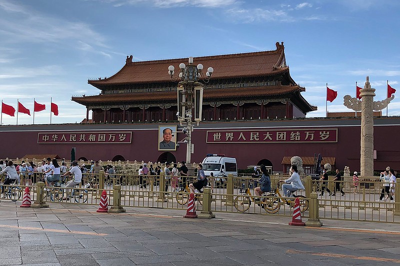 Residents past by a a police van parked in front of Tiananmen Gate in Beijing, Sunday, June 4, 2023. China tightened already strict access to Tiananmen Square in central Beijing on Sunday, the anniversary of 1989 pro-democracy protests. (AP Photo/Emily Wang Fujiyama)