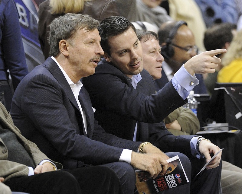FILE - Stan Kroenke, left, owner of the Denver Nuggets, and his son Josh Kroenke watch during the first quarter of an NBA basketball game between the Nuggets and the San Antonio Spurs on March 23, 2011, in Denver. Stan Kroenke's deal to purchase the Nuggets, along with the Colorado Avalanche and their home arena for $450 million, included a clause that tethered the NBA franchise to Denver for the ensuing 25 years. These days, the Nuggets are estimated by Forbes to be worth $1.93 billion. And all talk of them relocating no longer exists. (AP Photo/Jack Dempsey, File)