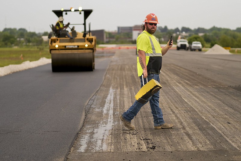 Road quality control Corey Prince finishes checking compaction of the road, Tuesday, May 23, 2023 at the Bentonville Municipal Airport in Bentonville.  (NWA Democrat-Gazette/Charlie Kaijo)