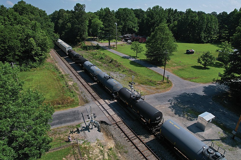 A freight train travels across a track intersecting Hensley Rd. with newly installed safety lights and arms on Friday, June 2, 2023 near Hensley. Until the new safety features and a track extension were built by Union Pacific, traffic was routinely stalled for extended periods of time at the intersection. (Arkansas Democrat-Gazette/Colin Murphey)