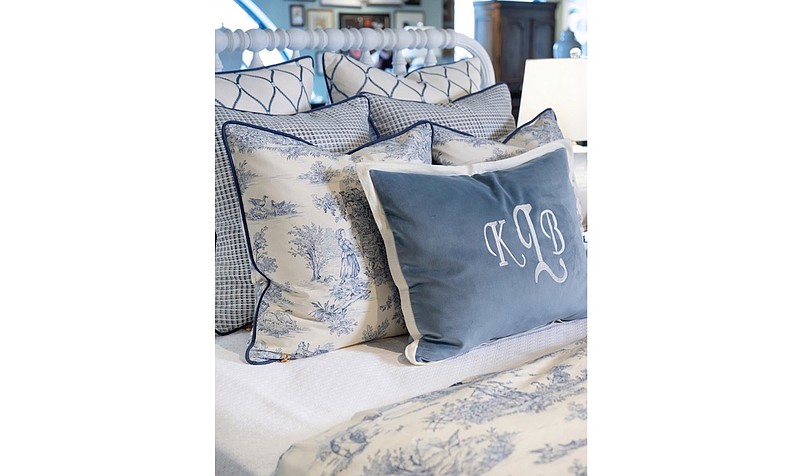 A classic blue and white traditional toile is the focal fabric for this bedding look that combines creams, whites, and multiple shades of blue for a refined yet relaxed bed. (TNS/Handout)