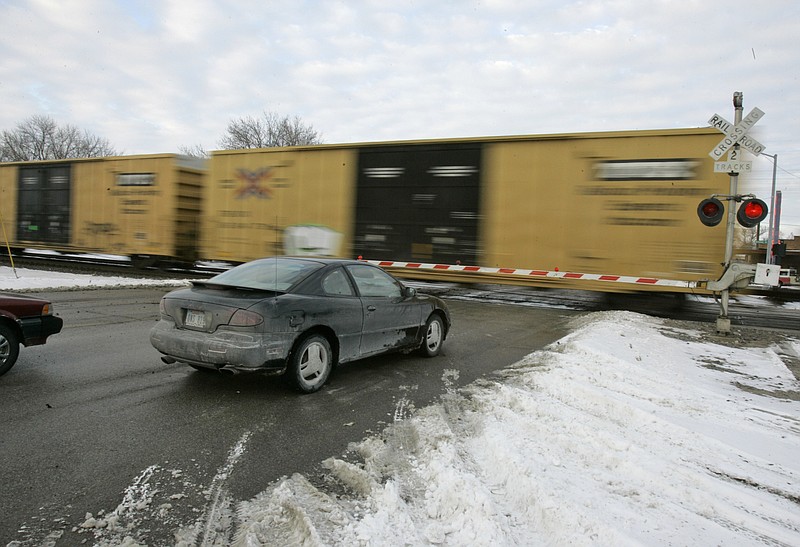 Cars wait for a train to pass Jan. 17, 2007, in Valley, Neb. With the rail industry relying on longer and longer trains to cut costs, the Biden administration is handing out $570 million in grants to help eliminate railroad crossings in 32 states. The grants announced Monday, June 5, 2023, will help eliminate more than three dozen crossings that delay traffic and sometimes keep first responders from where help is desperately needed. (AP Photo/Nati Harnik, File)