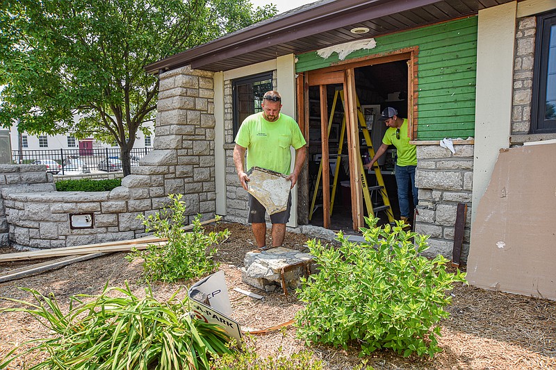 Julie Smith/News Tribune photo:
While Jacob Hoke works Monday, June 5, 2023, on the inside removing screws and nails from the interior wallboard and framework, Doug McBride resumes picking up rock from the exterior wall that was knocked loose from its mortar joints after someone crashed into the building Friday evening, June 2. The damage resulted in the large opening shown in the background. No one was injured in the accident.