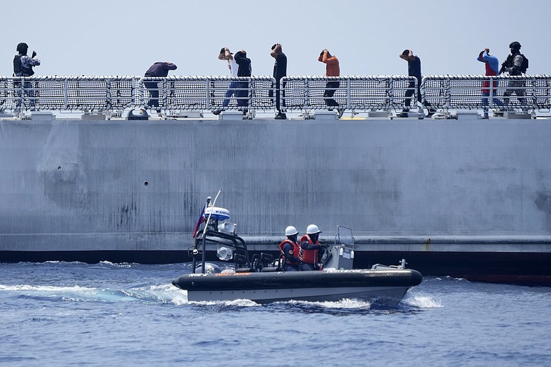 Mock suspects are escorted by armed Philippine Coast Guard personnel on board the PCG Melchora Aquino ship during a Coast Guard drill off the waters of Bataan, Philippines, Tuesday, June 6, 2023. U.S., Japan and Philippine coast guard ships staged law enforcement drills in waters near the disputed South China Sea on Tuesday as Washington pressed efforts to reinforce alliances in Asia amid an increasingly tense rivalry with China.(AP Photo/Aaron Favila)