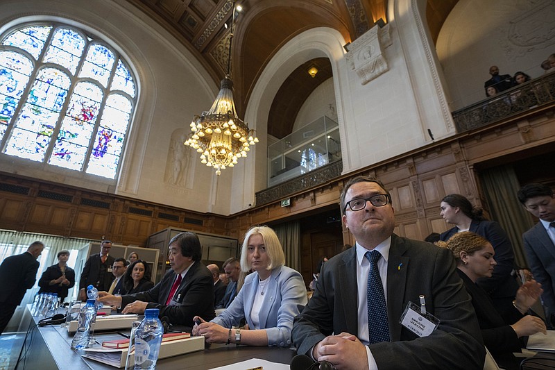 Ukraine's delegation with ambassador-at-large of the ministry of foreign affairs Anton Korynevych, right, and director general of international law of the ministry of foreign affairs Oksana Zolotaryova, second right, wait for judges to enter the World Court in The Hague, Netherlands, Tuesday, June 6, 2023. Four days of hearings open in a case brought by Ukraine against Russia at the UN's top court alleging that Russia breached treaties on terrorist financing and racial discrimination in eastern Ukraine and Crimea. (AP Photo/Peter Dejong)