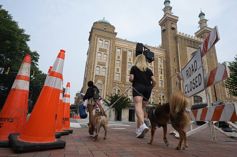 Pedestrians walk past the Altria Theater which was the site of a mass shooting after a graduation ceremony Wednesday, June 7, 2023, in Richmond, Va. (AP Photo/Steve Helber)