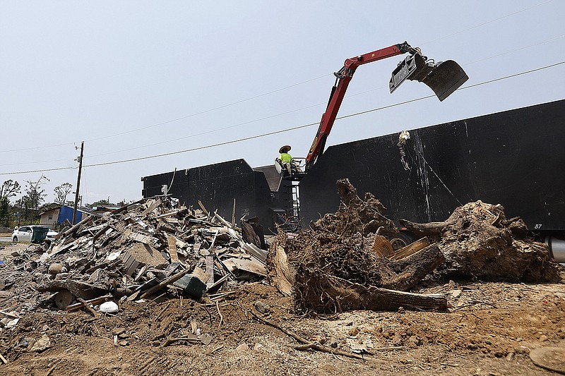 A Sunderland trucking contractor loads debris into a truck from a tornado-damaged house being torn down on Shackleford Road in the Walnut Ridge neighborhood on Wednesday, June 7, 2023, in Little Rock. The city of Little Rock has extended the deadline for debris pickup to June 25. 
(Arkansas Democrat-Gazette/Thomas Metthe)