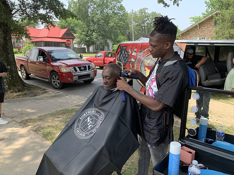 Collars Davis (left) gets a haircut on Thursday from Letez Glover, a barber student at Northern Technical College. (Pine Bluff Commercial/Byron Tate)