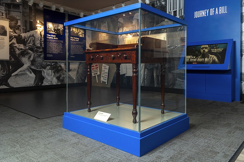 The desk on display at the LBJ Presidential Library, that President Lyndon B. Johnson sat at in the President's Room at the U.S. Capitol to sign the Voting Rights Act of 1965, on Aug. 6, 1965, is seen on May 16, 2023. (AP Photo/Stephen Spillman)