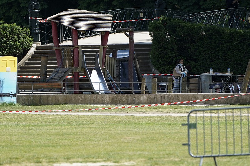 A police officer investigates at the scene after a knife attack Thursday, June 8, 2023 in Annecy, French Alps. A man with a knife stabbed several very young children, including at least one in a stroller, and also assaulted adults in a lakeside park in the French Alps. The savagery left at least two children and one adult with life-threatening injuries, authorities said. (AP Photo/Laurent Cipriani)