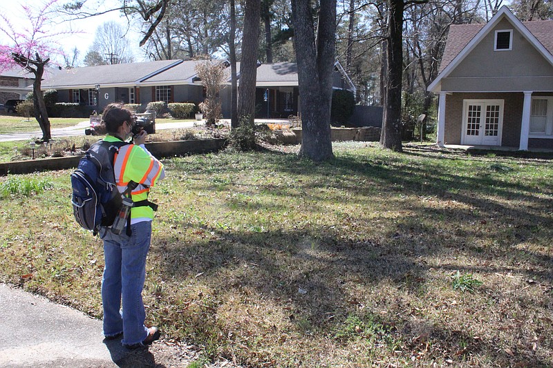 A surveyor from Terracon Consultant Services, Inc. surveys properties in the Mellor Park area in this 2020 file photo. The El Dorado Historic District Commission hopes to receive funding for another property survey in the future.