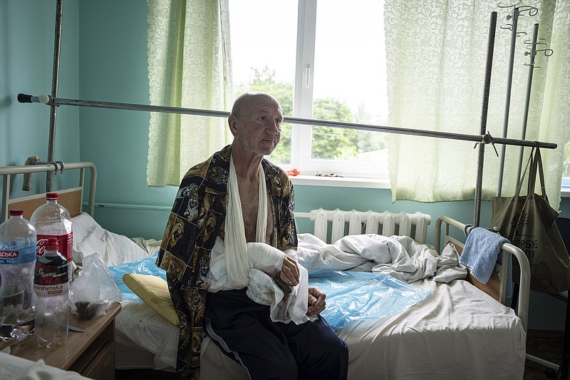 Vitalii Shpalin, 60, sits on a bed in a hospital in Kherson region, Ukraine, Monday, June 12, 2023, after he was shot on Sunday while fleeing on a boat from a flooded village on the left bank of the Dnipro river in Ukraine. (AP Photo/Evgeniy Maloletka)