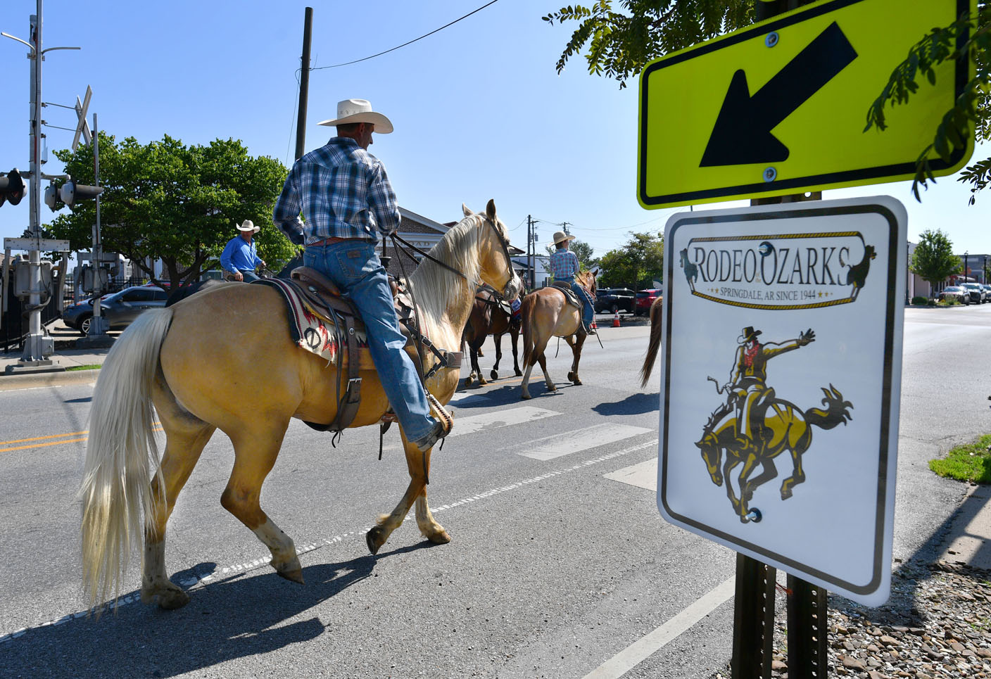 Cowboys drive horses through Springdale's Emma Avenue for rodeo