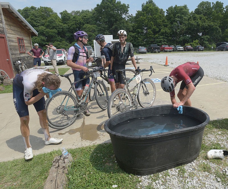 Gravel cycling racers, including Johnny Purvis (left) of Fayetteville, cool off on Saturday June 24 2023 at the finish area of the Highlands Gravel Classic cycling race held on rural roads in Northwest Arkansas. Go to nwaonline.com/photos for today's photo gallery. 
(NWA Democrat-Gazette/Flip Putthoff)