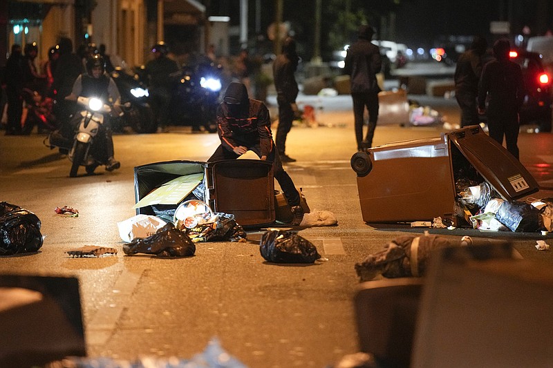 The Associated Press
Protesters block a street with garbage cans in Colombes, outside Paris, France, on Saturday. French President Emmanuel Macron urged parents Friday to keep teenagers at home and proposed restrictions on social media to quell rioting spreading across France over the fatal police shooting of a 17-year-old driver.
