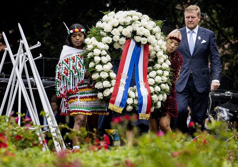 Dutch King Willem-Alexander lays a wreath at the slavery monument after apologising for the royal house's role in slavery and asked forgiveness in a speech greeted by cheers and whoops at an event to commemorate the anniversary of the country abolishing slavery in Amsterdam, Netherlands, Saturday, July 1, 2023. (Remko de Waal/Pool Photo via AP)
