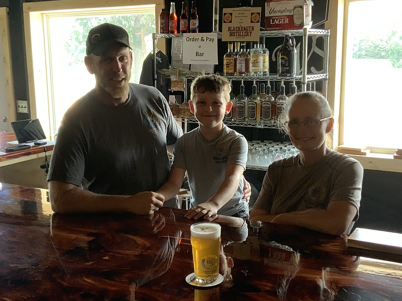 Democrat photo/Kaden Quinn: 
Brian and Leslie Welpman, of Welpman Springs Brewery, stand with their son ready to serve customers at their business' new taproom in Stover, Missouri.