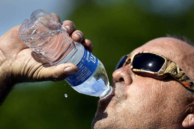 Robert Harris drinks water June 27 while taking a break from digging fence post holes in Houston. 
(File Photo/AP/David J. Phillip)