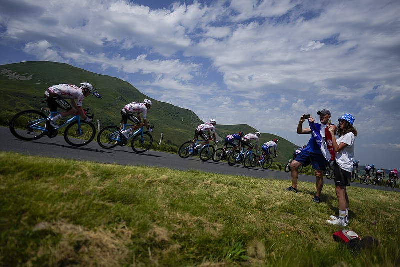 The pack speeds downhill during the tenth stage of the Tour de France cycling race over 167 kilometers (104 miles) with start in Vulcania and finish in Issoire, France, Tuesday, July 11, 2023. (AP Photo/Thibault Camus)