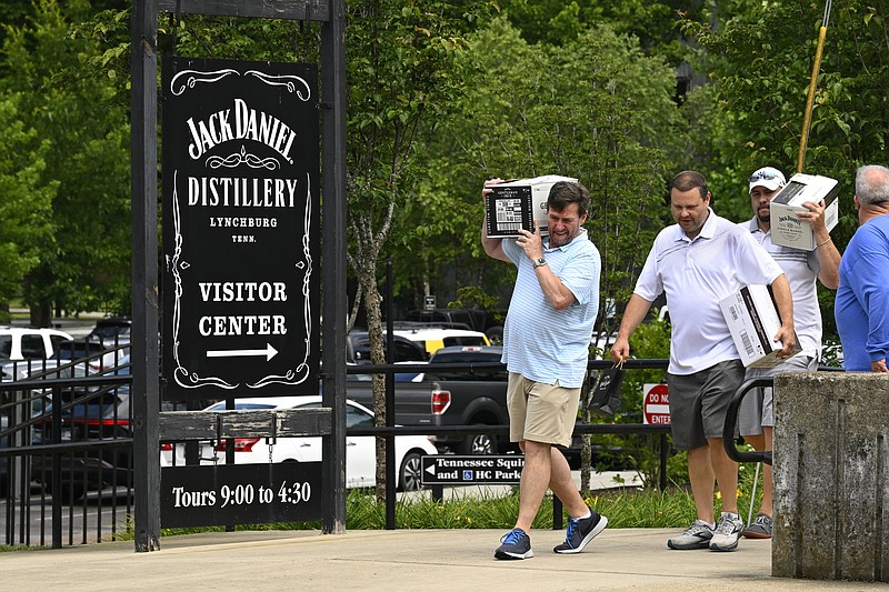 Visitors walk away from the Jack Daniels Distillery visitor center carrying boxes of whiskey June 14 in Lynchburg, Tenn. (AP/John Amis)