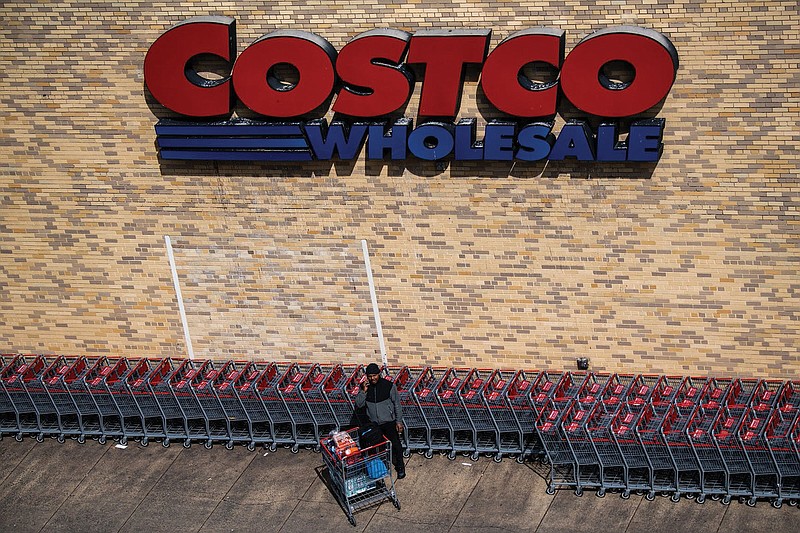 A shopper makes a call in March 2020 after leaving a Costco store in Arlington, Va. 
(File Photo/Washington Post)