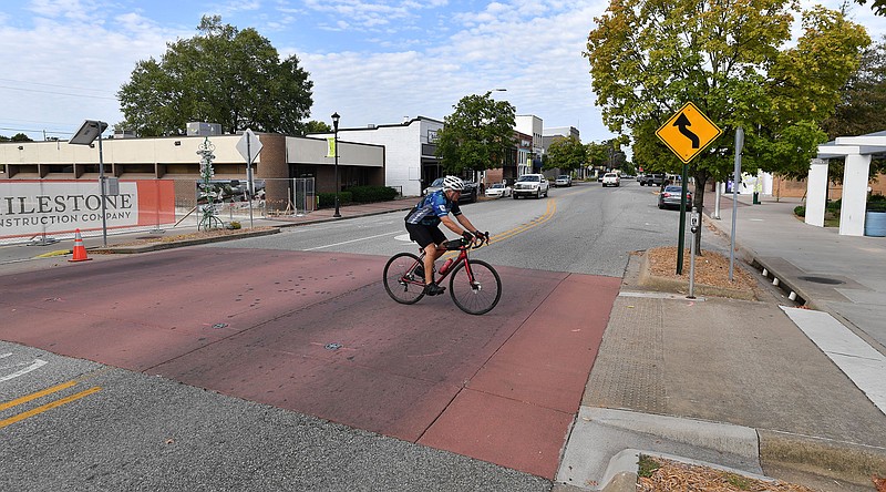 A cyclist rides north Sept. 23 across Emma Avenue near Shiloh Square in downtown Springdale. 
(File Photo/NWA Democrat-Gazette/Andy Shupe)