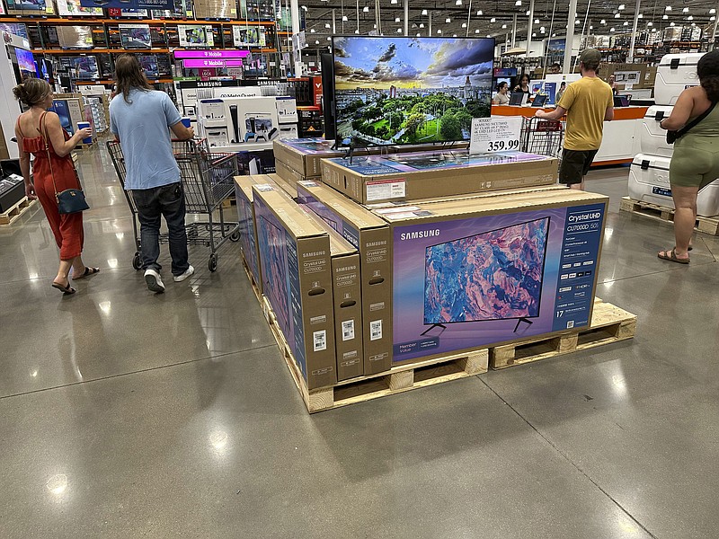 Shoppers glide past a display of big-screen televisions in a Costco warehouse on Tuesday, July 11, 2023, in Sheridan, Colo. On Tuesday, July 18, the Commerce Department releases U.S. retail sales data for June. (AP Photo/David Zalubowski)