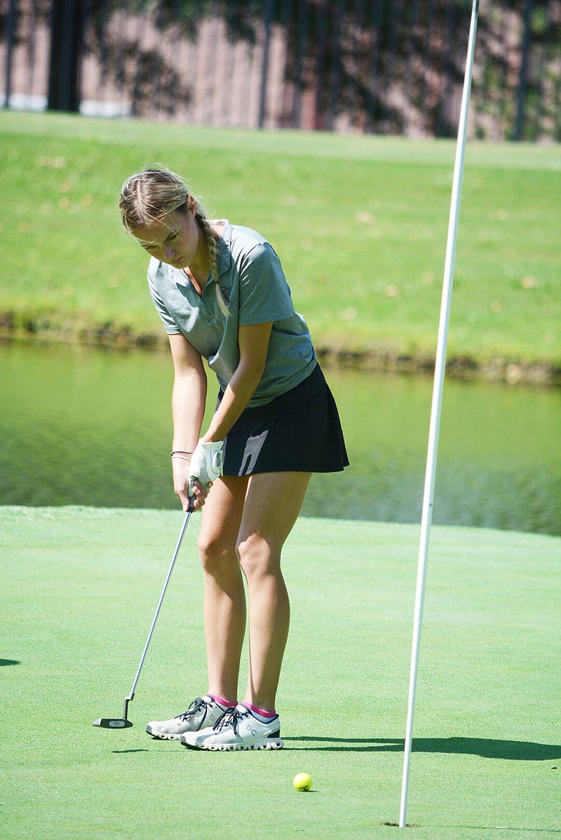 Bennett Horne/Herald-Leader Lady Panther junior Bailey Church rolls a put toward the cup on the No. 4 green Monday during her team's match with Lincoln on The Links course in Springdale.