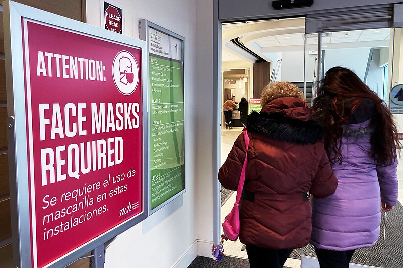 A sign announcing a face mask requirement is displayed at a hospital in Buffalo Grove, Ill., Friday, Jan. 13, 2023. COVID-19 hospital admissions are inching upward in the United States since early July 2023. It's a small-scale echo of the three previous summers. (AP Photo/Nam Y. Huh)